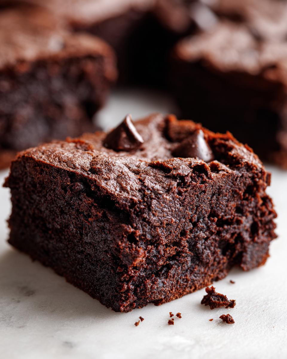 Close-up of a rich, fudgy square of sweet potato brownies topped with chocolate chips.