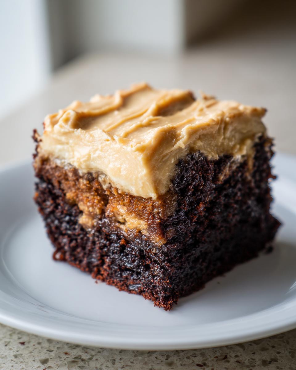 Close-up of a rich, dark chocolate banana bread brownies square topped with creamy peanut butter frosting.