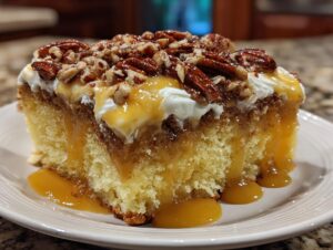 A moist slice of butter pecan praline poke cake topped with whipped cream, caramel sauce, and toasted pecans.