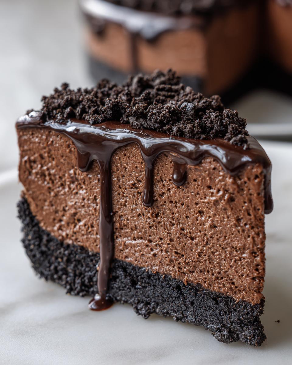 A decadent slice of chocolate mousse pie featuring a dark cookie crust, light mousse filling, and chocolate ganache drizzle.