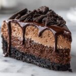 A rich slice of chocolate mousse pie featuring layers of dark crust, chocolate filling, light mousse, and chocolate drizzle.