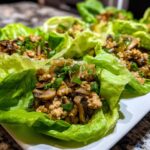 Close-up of savory chicken lettuce wraps filled with ground chicken, mushrooms, and green onions.