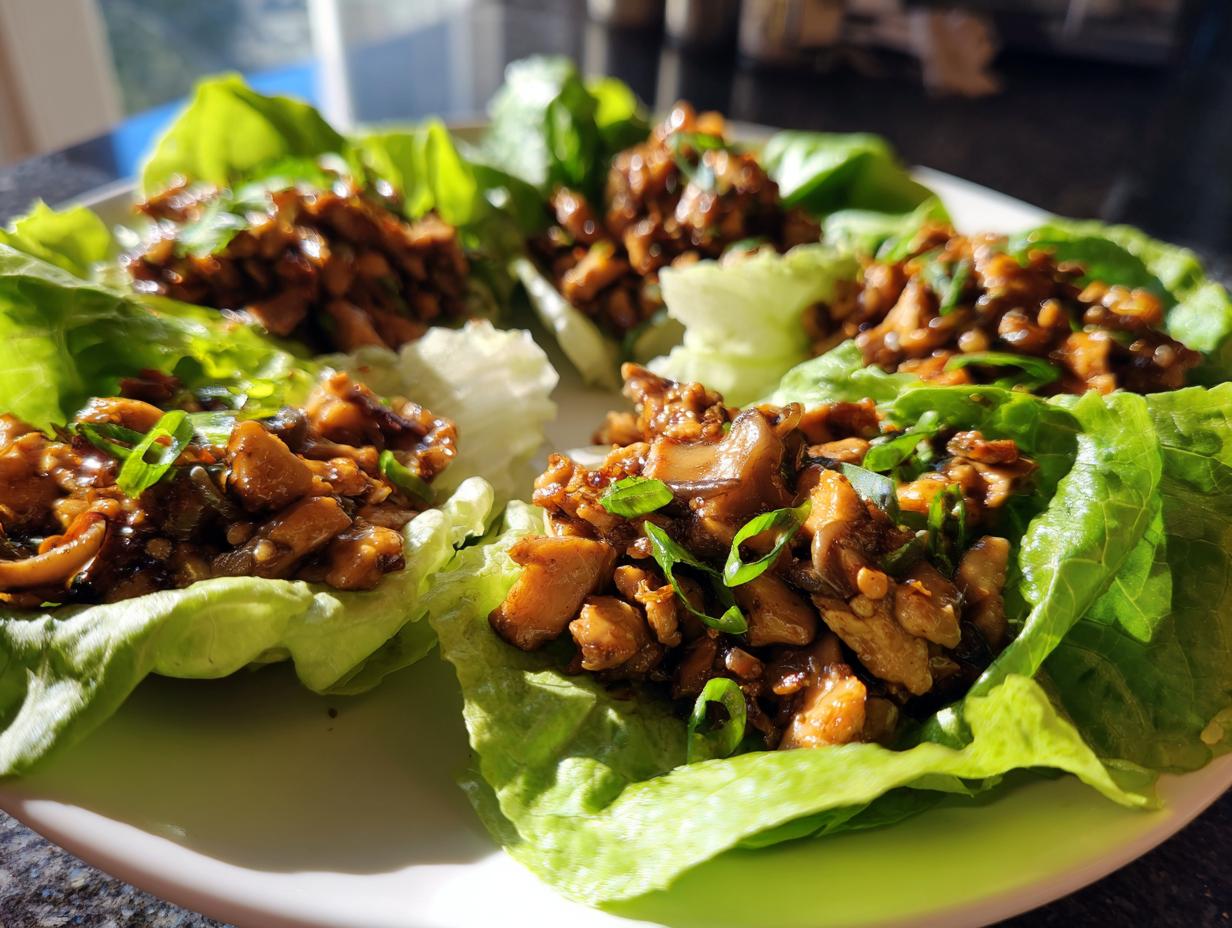 Four servings of amazing chicken lettuce wraps filled with savory brown chicken mixture and topped with green onions.