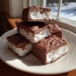 A stack of chocolate-covered squares featuring a fluffy white center, representing cool whip candy.