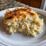 A close-up serving of creamy french onion butter rice with a deeply browned, cheesy crust on top.