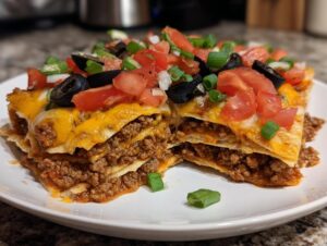 A cross-section slice of a layered Mexican pizza copycat, showing seasoned ground beef, melted cheese, and fresh toppings.