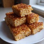 A stack of golden brown, perfectly formed crispy rice squares showing a crunchy, caramelized top layer.