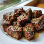 Close-up of perfectly seared, bite-sized pieces of hibachi steak seasoned with herbs and spices.