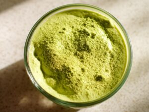 Overhead close-up of vibrant green matcha chia pudding topped with a dusting of matcha powder.