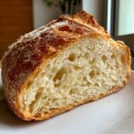 Close-up of the open crumb structure of a freshly baked sourdough bread loaf.