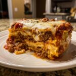 A thick, layered slice of crockpot ravioli lasagna topped with melted cheese and meat sauce.