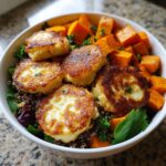 Close-up of a vibrant halloumi sweet potato bowl featuring pan-fried halloumi slices over quinoa and roasted sweet potatoes.