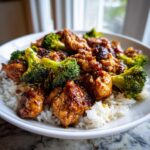Close-up of glazed Miso Chicken and Rice served with bright green broccoli florets in a white bowl.