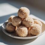 A stack of homemade no-bake margarita balls coated generously in granulated sugar, resting on a small plate.