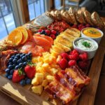 A vibrant and abundant Breakfast Grazing Board featuring smoked salmon, bacon, cheese cubes, fresh berries, sliced bread, and dips.